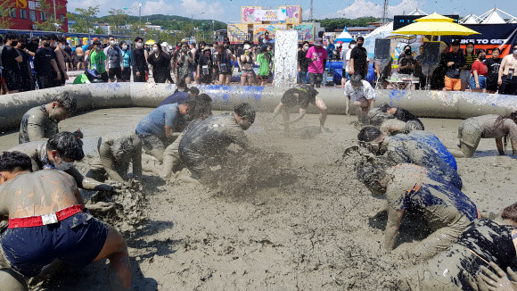 서해안권 첫 해양 국제행사인 ‘2022 보령 해양머드박람회’와 제25회 보령 머드축제가 16일 대천해수욕장 일대에서 개막한 가운데 입장객들이 신나는 머드체험을 하고 있다. 2022.7.16  연합뉴스