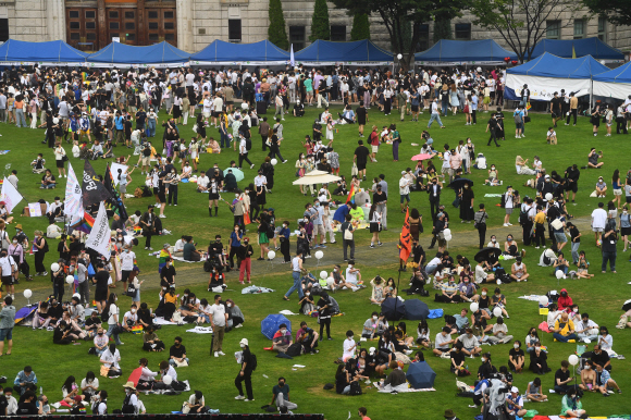 16일 서울광장에서 열린 퀴어문화축제 참가자들이 잔디에 앉아 행사를 즐기고 있다. 안주영 전문기자