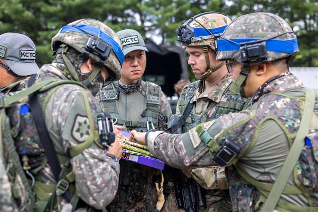 육군은 오는 21일까지 강원도 인제 육군과학화전투훈련단(KCTC)에서  ‘KCTC 여단급 쌍방훈련’을 진행한다고 18일 밝혔다.  이 훈련은 1개 여단이 전문대항군 부대와 교전했던 기존 훈련과 달리 1회 훈련에 2개 여단을 참가시켜 더 많은 부대가 실전에 가장 가깝단 평가를 받는 KCTC 훈련을 경험토록 하자는 취지에서 도입됐다. 한미 장병들이 작전토의를 하고 있다. 2022.7.18 육군 제공