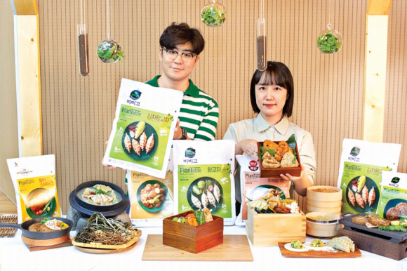 CJ제일제당 관계자들이 100% 식물성 식품 브랜드 ‘플랜테이블’의 신제품 김치왕교자와 주먹밥을 소개하고 있다. CJ제일제당 제공