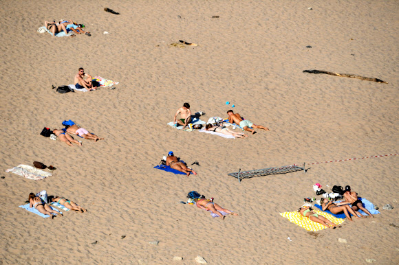 18일(현지시간) 네덜란드 네이메헌의 발 강 근처에서 사람들이 일광욕을 즐기고 있다. 로이터 연합뉴스