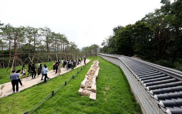 20일 서울 종로구 와룡동 율곡로 터널 상부에서 ‘창경궁?종묘 연결 역사복원사업’ 프레스 투어가 열린 가운데 취재진들이 역사복원 공간을 둘러보고 있다. 서울시는 일제가 1932년 ‘종묘관통도로’(율곡로)를 개설하면서 단절한 녹지축을 잇고 일제가 없애버린 창경궁과 종묘 사이 궁궐담장과 북신문도 최대한 원형 그대로 복원했다. 2022.7.20  공동취재단