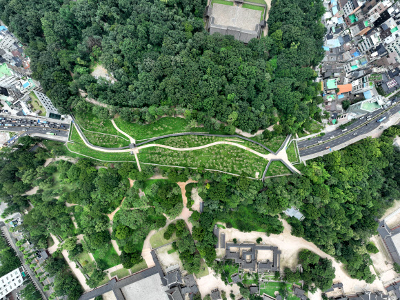 서울시가 창경궁과 종묘를 90년 만에 다시 연결하는 ‘창경궁·종묘 연결 역사복원사업’을 완료했다고 20일 밝혔다.  담장을 사이에 두고 숲으로 이어져 있던 종묘와 창경궁은 일제가 1932년 ‘종묘관통도로’(율곡로)를 개설하면서 단절됐다. 사진은 하늘에서 본 역사복원공간. 2022.7.20  서울시 제공