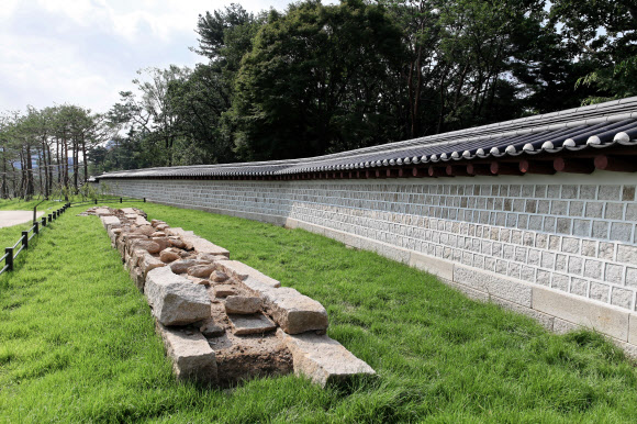 서울시가 창경궁과 종묘를 90년 만에 다시 연결하는 ‘창경궁·종묘 연결 역사복원사업’을 완료했다고 20일 밝혔다.  담장을 사이에 두고 숲으로 이어져 있던 종묘와 창경궁은 일제가 1932년 ‘종묘관통도로’(율곡로)를 개설하면서 단절됐다. 사진은 복원된 담장과 기초석. 2022.7.20  서울시 제공