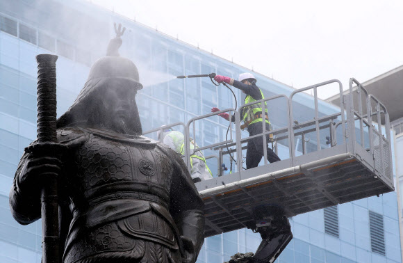 서울시 관계자들이 21일 서울 광화문광장에서 이순신 장군 동상을 세척하고 있다. 2022.07.21 공동취재사진