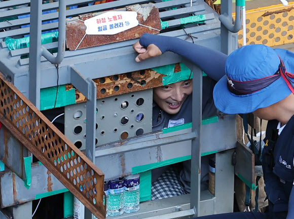 대우조선해양 하청노조 파업 51일째인 22일 오전 경남 거제시 대우조선해양 옥포조선소 1독의 가로, 세로, 높이 각 1ｍ 철 구조물에서 31일째 농성을 이어가고 있는 유최안 금속노조 거제통영고성 조선하청지회 부지회장이 관계자와 이야기를 나누고 있다. 2022.7.22 연합뉴스.