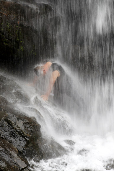 24일 전남 구례군 산동면 수락폭포에서 피서객이 떨어지는 물줄기를 맞고 있다. 2022.7.24  연합뉴스