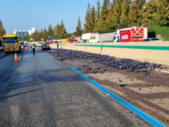 28일 5시11분께 충북 청주시 옥산면 경부고속도로 서울방향 309㎞ 지점에서 1차로로 주행하던 A(61)씨의 25t 화물차량이 앞서가던 승용차를 추돌한 뒤 중앙분리대를 들이받았다. 이 충격으로 화물차량에 실려있던 맥주 200박스가 도로 양방향에 떨어졌다. 2022.07.28. 충북경찰청 제공