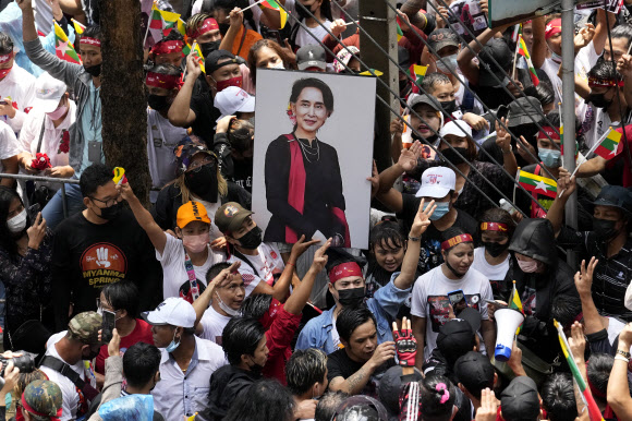 태국에 거주하는 미얀마 사람들이 26일 태국 방콕에 있는 미얀마 대사관 앞에서 퇴임한 미얀마 지도자 아웅산 수치의 사진을 들고 있다. 방콕 AP 뉴시스