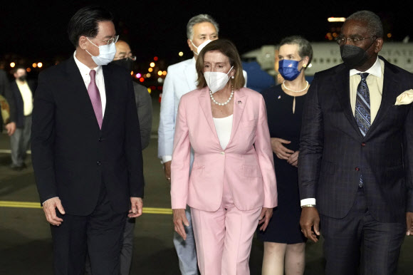 중국의 강력한 반발에도 대만을 방문한 낸시 펠로시(가운데) 미국 하원의장이 2일 밤 타이베이 쑹산 공항에 도착하고 있다. 왼쪽은 펠로시 의장을 영접하러 나온 우자오셰 대만 외교부장. 2022.8.2 AP 연합뉴스