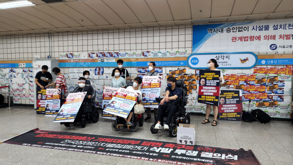 전국장애인차별철폐연대(전장연) 회원들이 3일 서울 용산구 4호선 삼각지역 승강장에서 장애인 권리 예산 보장을 촉구하며 입장을 밝히고 있다. 2022.8.3  연합뉴스