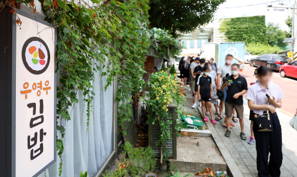 4일 오전 드라마 ‘이상한 변호사 우영우’ 촬영지인 경기도 수원시 팔달구 행궁동의 한 식당에 시민들이 입장을 기다리며 줄을 서 있다. 2022.8.4  연합뉴스