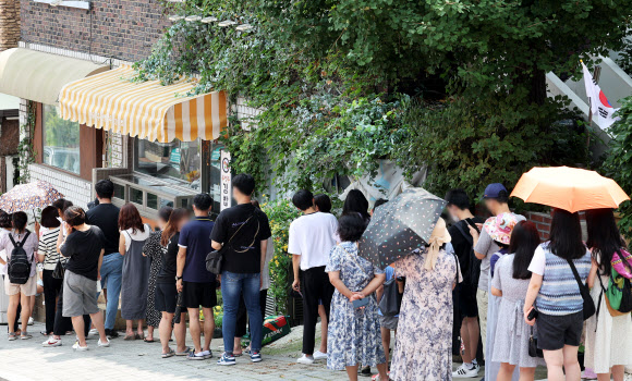 4일 오전 드라마 ‘이상한 변호사 우영우’ 촬영지인 경기도 수원시 팔달구 행궁동의 한 식당에 시민들이 입장을 기다리며 줄을 서 있다. 2022.8.4  연합뉴스