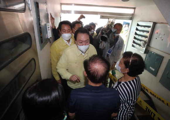 윤석열 대통령이 9일 침수피해 사망사고가 발생한 서울 신림동 빌라를 찾아 주민들과 대화하고 있다.  왼쪽은 오세훈 서울시장. 2022. 8. 9 박지환 기자