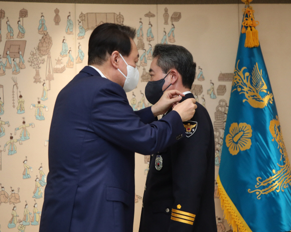 윤석열 대통령이 10일 용산 대통령실 청사에서 윤희근 경찰청장에게 임명장을 수여하기 계급장을 달아주고 있다.  2022. 8. 10 박지환 기자