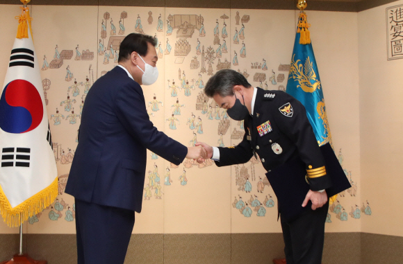 윤석열 대통령이 10일 용산 대통령실 청사에서 윤희근 경찰청장에게 임명장을 수여한 뒤 악수하고 있다. 2022. 8. 10 박지환 기자