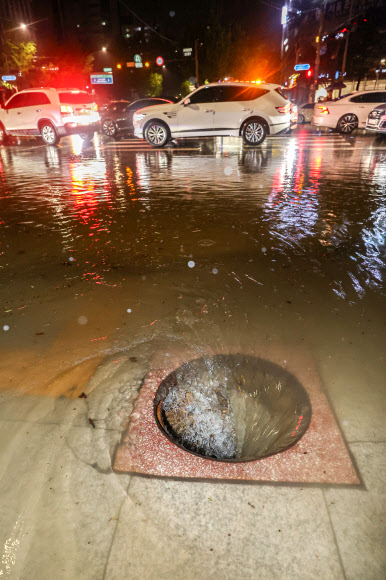이틀째 폭우가 쏟아졌던 지난 9일 서울 강남구 대치사거리의 뚜껑이 사라진 맨홀 아래로 빗물이 빨려 들어가고 있다. 연합뉴스