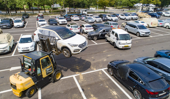 18일 경기도 과천시 서울대공원 침수차 임시 적치장에서 관계자들이 침수차들을 지게차와 견인차를 이용해 옮기고 있다. 2022.8.18  연합뉴스