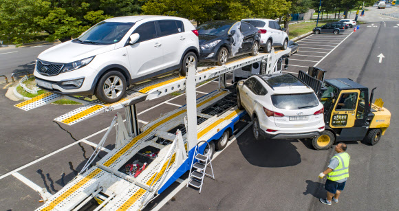 18일 경기도 과천시 서울대공원 침수차 임시 적치장에서 관계자들이 침수차들을 폐차장으로 옮기기 위해 트럭에 싣고 있다. 2022.8.18  연합뉴스