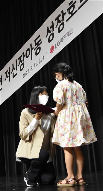 19일 서울 강서구 마곡 LG사이언스파크에서 진행된 ‘저신장 아동 성장호르몬제 기증식’에서 구연경(왼쪽) LG복지재단 대표이사가 어린이에게 기증서를 전달하고 있다. LG 제공