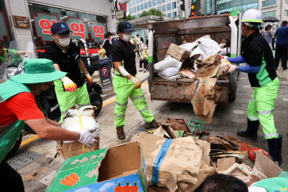 서울시 관계자들이 폭우로 침수 등 피해를 입은 서울 동작구 남성사계시장에서 발생한 쓰레기를 정리하고 있다.-연합뉴스