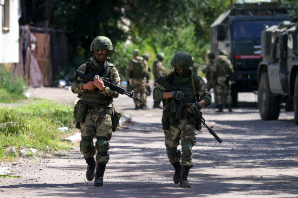 러시아에 점령된 우크라이나 남동부 항구도시 마리우폴에서 병사들이 포격으로 파괴된 거리를 걷고 있다. 2022.8.22 타스 연합뉴스