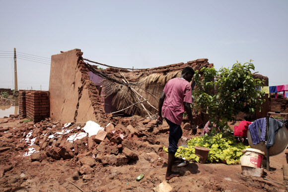 수단 하르툼 남동쪽 알자지라주 엘마나킬 지구의 한 마을 주민이 폭우로 인해 파손된 집을 점검하고 있다. 동아프리카 전역의 폭우로 22일(현지시간)까지 수단에서 80명 넘는 사망자가 발생했다. 2022.8.23 AP 연합뉴스