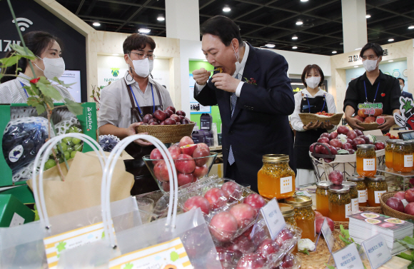 윤석열 대통령이 24일 서울 서초구 aT센터에서 열린 ‘2022 A FARM SHOW(에이팜쇼)-창농·귀농 고향사랑 박람회’에서 청년농부사관학교 졸업생들의 부스를 찾아 백향과를 시식하고 있다. 2022. 8. 24 박지환 기자