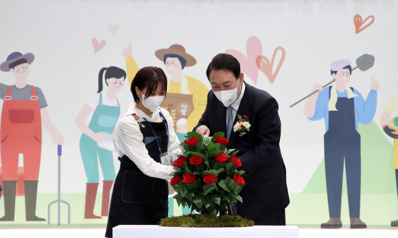 윤석열 대통령이 24일 서울 서초구 aT센터에서 열린 ‘2022 A FARM SHOW(에이팜쇼)-창농·귀농 고향사랑 박람회’에서 청년농업인 박지현 힙토 대표와 함께 화분에 물을 주는 개막 세리머니를 하고 있다. 2022. 8. 24 박지환 기자