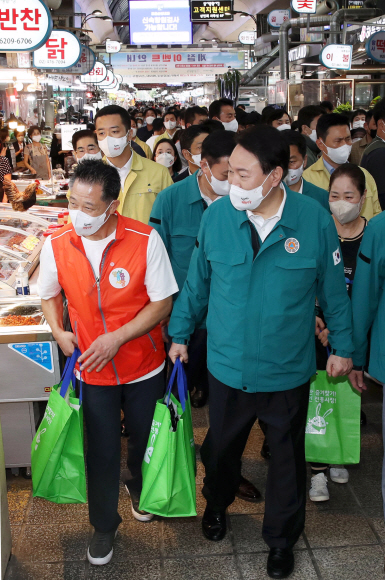 윤석열 대통령이 25일 오전 서울 강동구 암사종합시장을 방문, 한 반찬가게에서 온라인으로 주문된 상품의 배송을 체험하고 있다. 2022. 8. 25. 박지환 기자