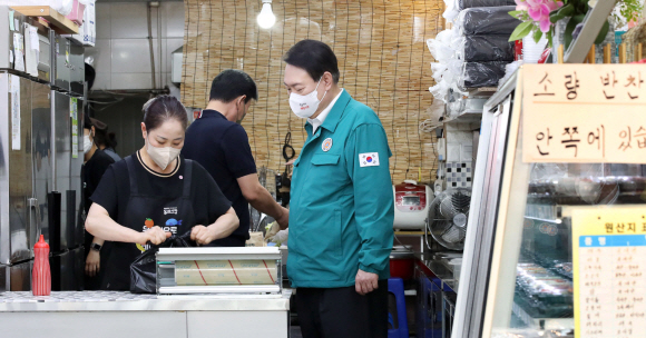 윤석열 대통령이 25일 서울 강동구 암사종합시장을 방문해 한 반찬가게에서 온라인으로 주문된 상품 패킹 및 배송 시연을 지켜보고 있다. 2022. 8. 25. 박지환 기자