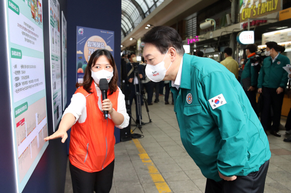 윤석열 대통령이 25일 서울 강동구 암사종합시장을 방문해 나유미 암사종합시장 디지털매니저로부터 시장 및 디지털 전환 현황 보고를 받고 있다. 2022. 8. 25. 박지환 기자