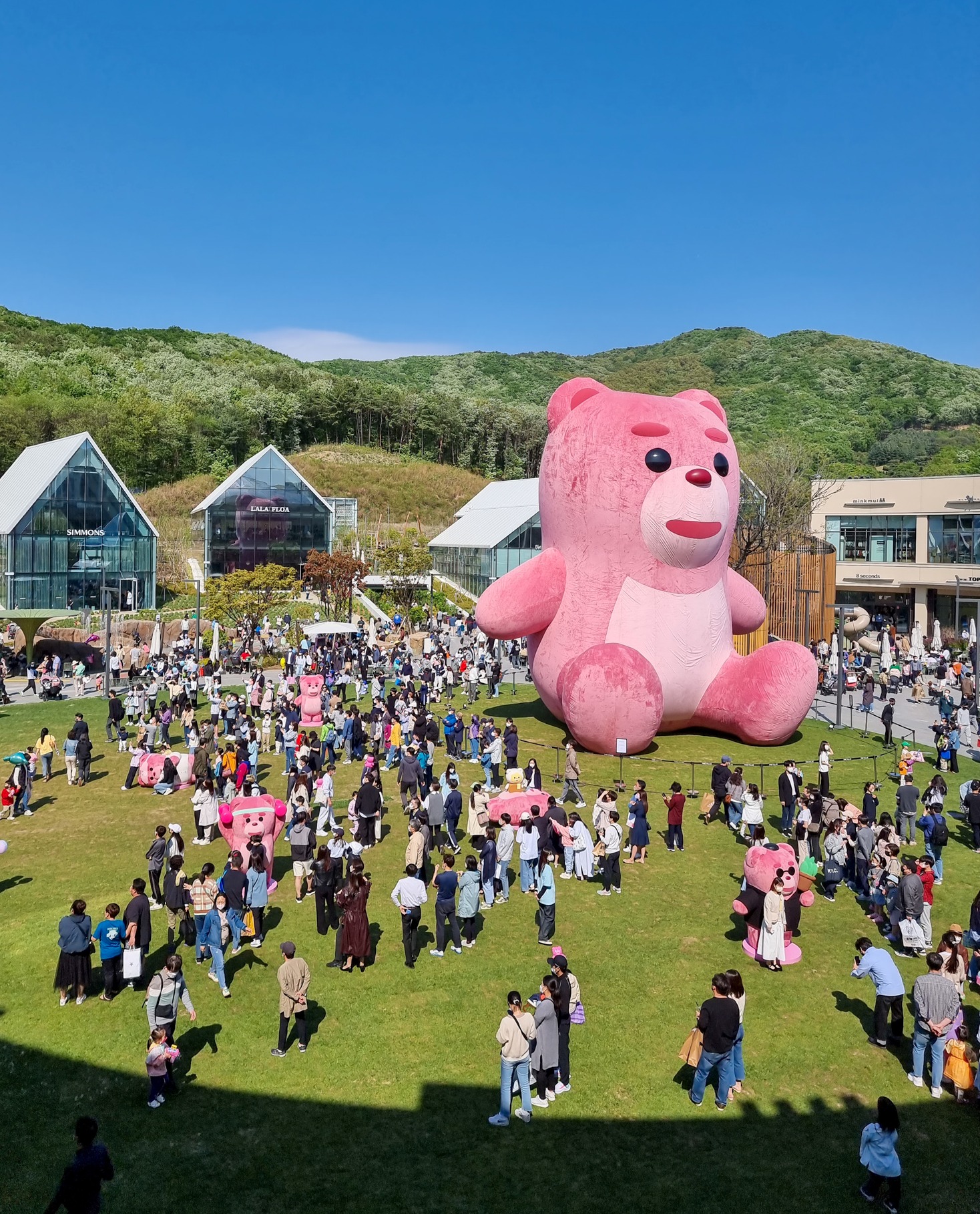 지난 5월 타임빌라스를 찾은 고객들이 잔디광장에 설치된 15m 높이의 초대형 ‘벨리곰’을 구경하고 있다. 롯데쇼핑 제공 