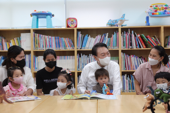 윤석열 대통령이 30일 오전 서울 구로구 가족통합지원센터를 방문해 다문화가정 등을 위한 공동육아나눔터에서 동화책 ‘공룡똥’ 읽기를 함께하며 참가 가족들과 대화하고 있다. 2022. 8. 30 대통령실 제공