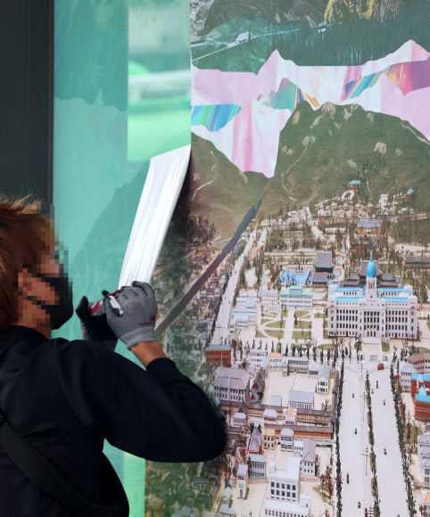 30일 오후 최근 재개장한 서울 광화문광장 버스정류장에서 서울시 관계자들이 조선총독부 등이 포함된 대형 포스터를 제거하고 있다. 2022.8.30  연합뉴스