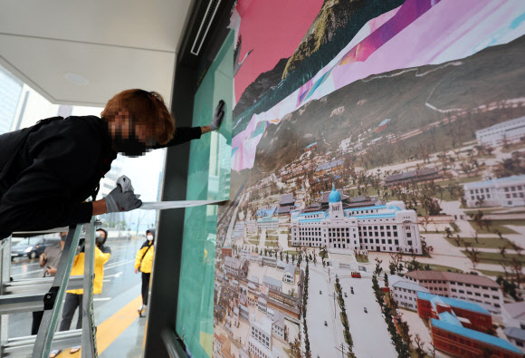30일 오후 최근 재개장한 서울 광화문광장 버스정류장에서 서울시 관계자들이 조선총독부 등이 포함된 대형 포스터를 제거하고 있다. 2022.8.30  연합뉴스
