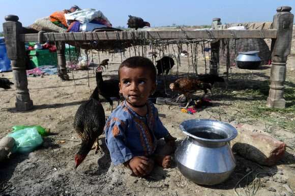 파키스탄에 사상 최악의 홍수가 발생하면서 지난 3개월간 1100여명이 숨지고 13조원 이상의 재산 피해가 발생한 것으로 집계됐다. 사진은 파키스탄 신드주 시카르푸르에서 이재민 가족의 한 어린이가 마른 땅에 앉아 있는 모습. 2022.8.30 AFP 연합뉴스
