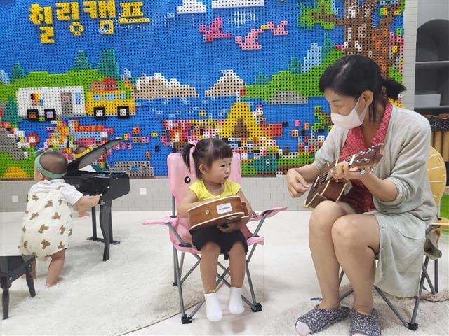 지난 9월 운영한 영유아 놀이 돌봄 서비스 사전체험에서 아이가 돌봄교사와 악기연주 놀이를 하고 있다. 서울신문 DB