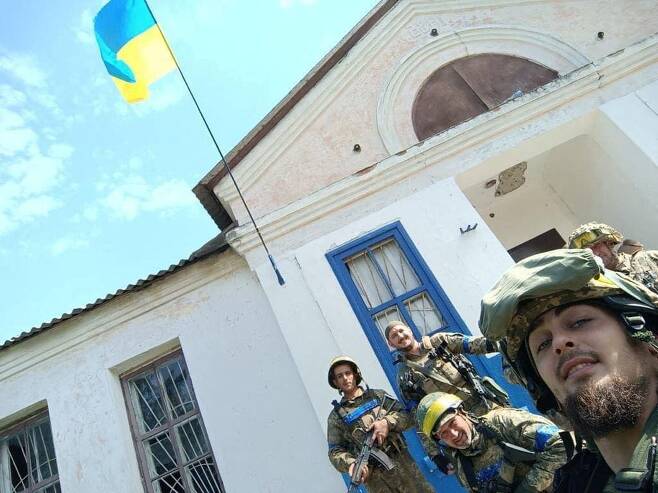 우크라이나 병사들이 하르키우주 바실렌코프 마을을 탈환한 후 우크라이나 국기 앞에서 기념 셀카를 찍고 있다. 로이터 연합뉴스