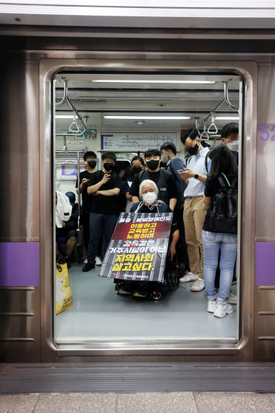 박경석 전국장애인차별철폐연대(전장연) 대표가 13일 오전 서울 5호선 광화문역에서 장애인권리예산 삭감을 규탄하며 지하철에 탑승하고 있다. 전장연은 이날 오전 4호선 삼각지역에서 2개 조로 나눠 출발해 2, 4, 5, 9호선 등 지하철에 탑승해 국회의사당역으로 향했다. 2022.9.13  연합뉴스