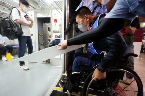 박경석 전국장애인차별철폐연대(전장연) 대표가 13일 오전 서울 5호선 광화문역에서 장애인권리예산 삭감을 규탄하며 지하철에 탑승하고 있다. 전장연은 이날 오전 4호선 삼각지역에서 2개 조로 나눠 출발해 2, 4, 5, 9호선 등 지하철에 탑승해 국회의사당역으로 향했다. 2022.9.13  연합뉴스