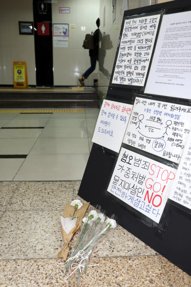 15일 오후 20대 여성 역무원 살인 사건이 발생한 서울 신당역 여자화장실 앞에 추모의 꽃과 혐오 범죄 중단을 촉구하는 글이 놓여 있다.  연합뉴스