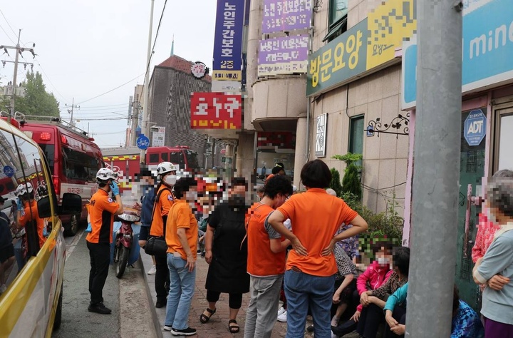 김포시 노인주간보호센터에서 돌보믈 받는 어르신들이 14일 화재를 피해 건물밖으로 대피해 있다. 김포소방서 제공