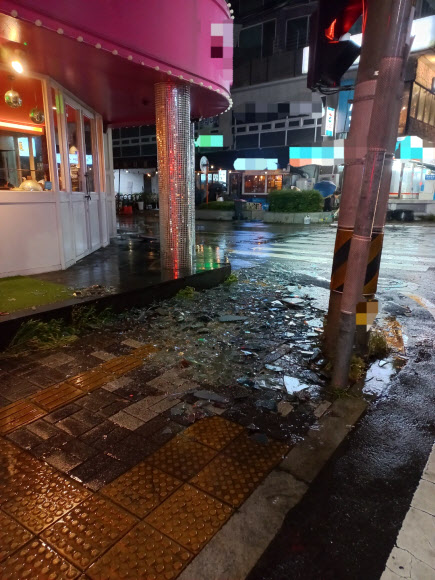 제14호 태풍 ‘난마돌’이 북상하는 상황 속 18일 오후 부산 수영구의 한 건물 유리창이 강풍에 의해 아래로 떨어져 현장에 출동한 소방이 안전조치를 하고 있다. 부산소방재난본부 제공