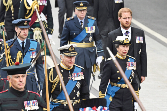 74세에 왕위에 오른 찰스 3세 국왕과 윌리엄·해리 왕자 등 영국 왕실 일가가 군복 차림으로 운구되는 엘리자베스 2세 여왕의 관을 뒤따르고 있다. 런던 AFP 연합뉴스