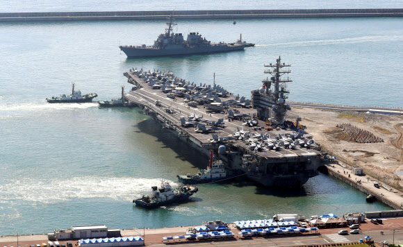 미국 해군의 핵추진 항공모함 ‘로널드 레이건함’(CVN-76)과 이지스 구축함 ‘배리함’(DDG-52) 등 항모강습단이 23일 오전 부산 남구 해군작전사령부 부산작전기지에 입항하고 있다. 이 항모는 길이 333m, 폭 77m, 높이 63m 규모이며, 승조원 5500~6000명이다. ‘떠다니는 군사기지’로 불리는 이 항모는 전투기 FA-18(슈퍼호넷), F-35C 전투기 등 80여 대의 항공기를 탑재하고 있다. 2022.09.23. 뉴시스