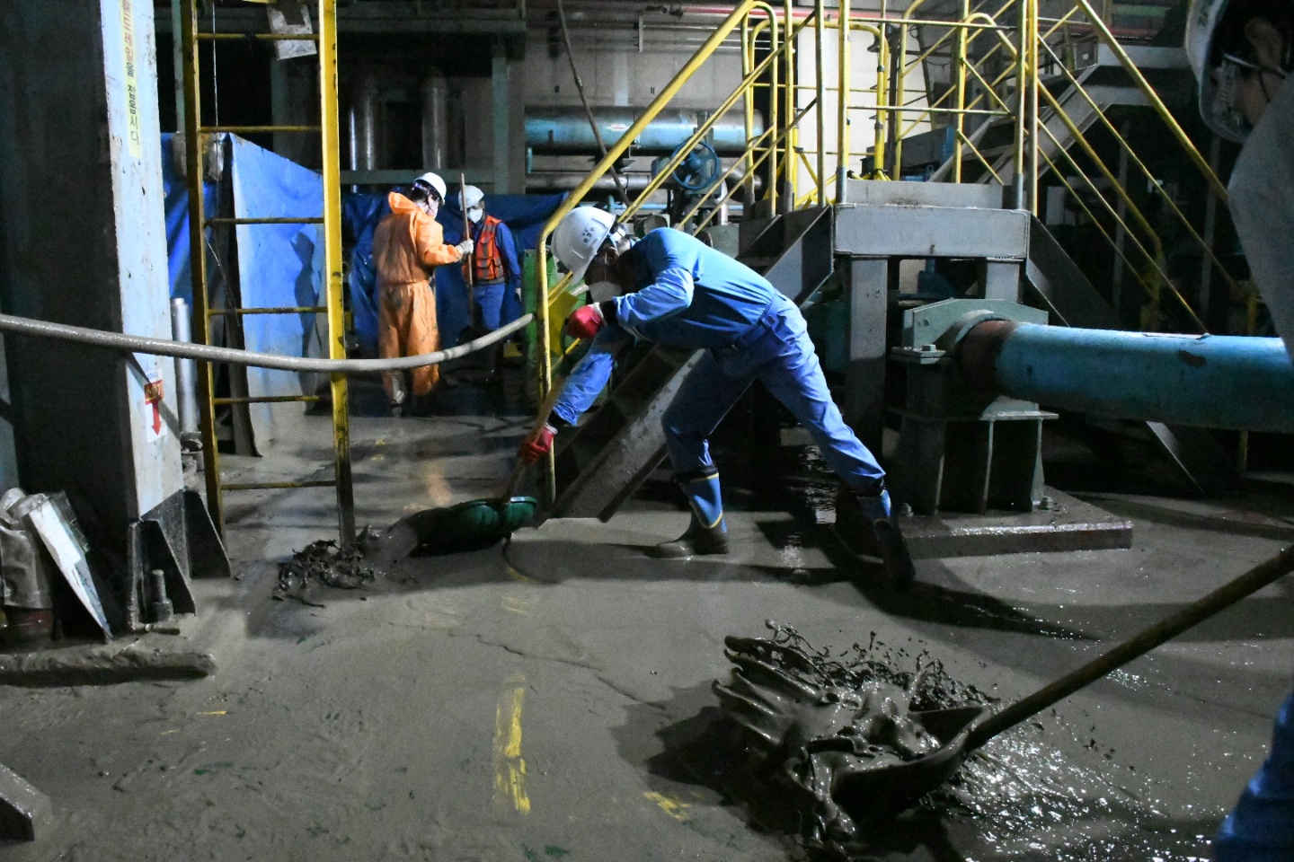 최정우 포스코그룹 회장(오른쪽)이 지난 17일 침수 피해를 입은 포항제철소 후판공장 지하에서 직원들과 함께 토사 제거 작업을 하고 있다. 포스코 제공