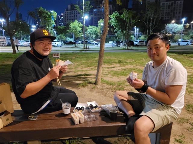 18일 밤 11시가 넘은 시각 장사를 끝낸 장현(왼쪽)·최낙규씨가 한강공원 벤치에 앉아 김밥과 샌드위치로 요기를 하고 있다. 신융아 기자