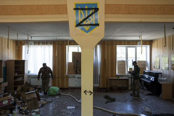 러 침공 옹호 ‘Z표식’ 그려진 교실 조사하는 우크라이나 군인