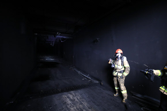 대전 현대프리미엄아울렛 화재 이튿날인 27일 오전 화마가 휩쓸고 지나간 지하주차장 입구 모습을 소방대원이 설명하고 있다. 2022.9.27  연합뉴스